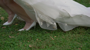 穿着结婚礼服的年轻新娘在公园里散步9秒视频