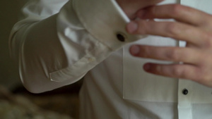 男子穿白色衬衫戴上袖扣12秒视频