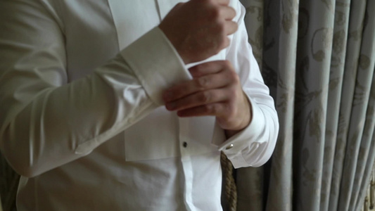 商人佩戴手铐链男子穿白色衬衫上戴上和调整袖扣视频