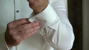男子穿白色衬衫戴上袖扣6秒视频