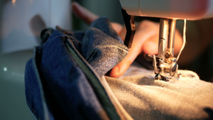 关闭一名妇女缝纫用缝纫机修补蓝色牛仔裤和缝纫机13秒视频