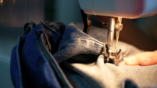 四千片段一名妇女用缝纫机缝上蓝色牛仔裤视频