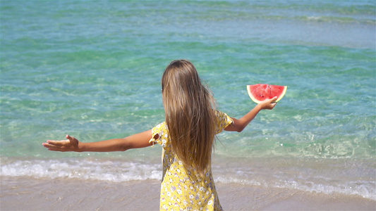 快乐的女孩在沙滩上玩乐吃西瓜视频