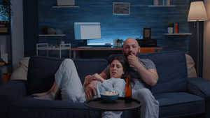 在电视上看恐怖电影时惊吓着吃爆米花的年轻夫妇21秒视频