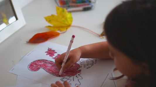 小女孩在纸页上涂着松鼠的画像上面印着红标记视频