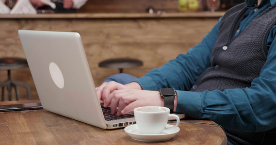 男性用手在笔记本电脑上打文字和喝咖啡视频