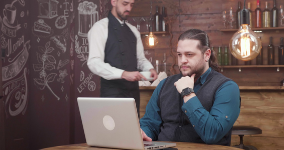 英俊的男性自由职业男子在笔记本电脑上工作喝咖啡视频
