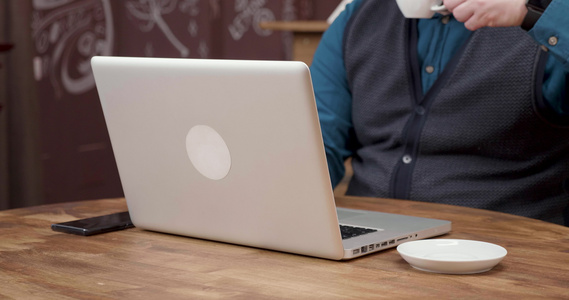 男人在笔记本电脑上工作时喝点咖啡视频