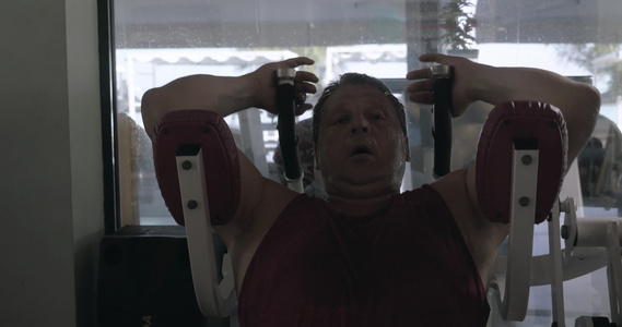 男人在体操和出汗中用模拟器做腹部运动视频