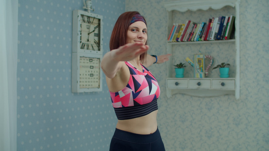 30多岁的年轻女子穿着运动服在家做健身运动女性做运动视频