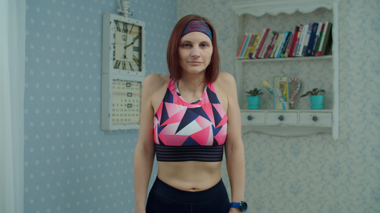 30多岁的年轻女子穿着运动服在家做健身运动女性做运动视频