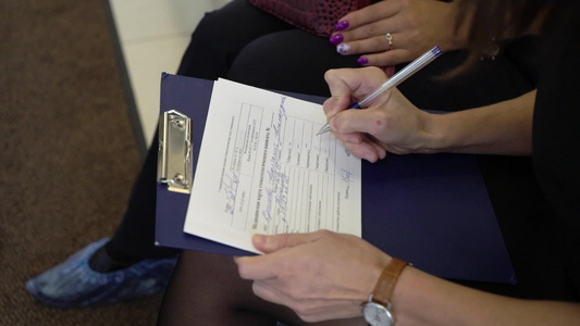 女性病人正在医疗办公室签署一些文件在医院里视频