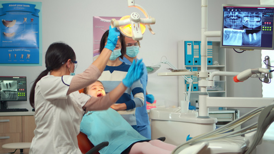 配备手套的牙医技师向儿童病人解释这个过程视频
