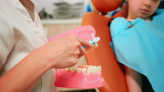 近距离关闭牙医展示专业的牙齿刷牙工作视频