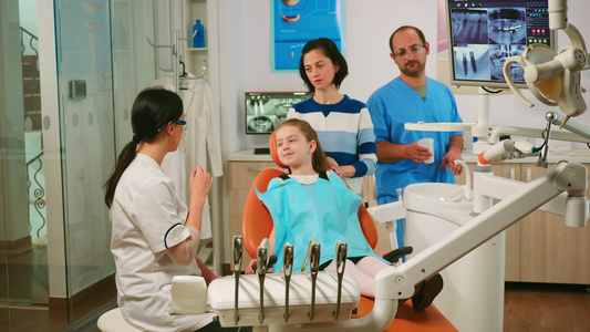 口腔学家向小女孩解释牙齿的清洗过程并向她们解释视频