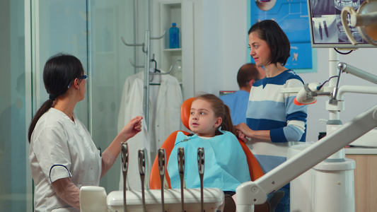 儿科女牙医在口腔诊所治疗小女孩病人;和视频