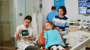 儿童坐在口腔病理椅子上听儿科医生在看药片19秒视频