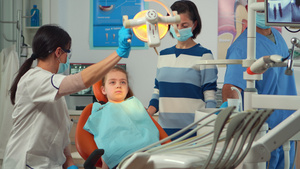 与护士和小女病人一起在牙科科工作的儿科牙医医生21秒视频