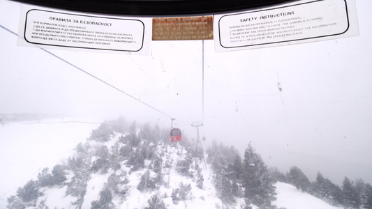 Gondola滑雪电梯的一扇被刮破的肮脏窗户上贴有视频