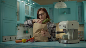 戴眼镜的年轻成年女性拿着纸袋里面装着新鲜的食物在家里30秒视频