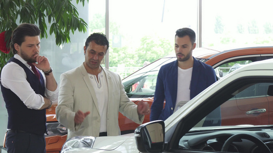 三名男性朋友在经销店检查汽车销售情况视频