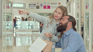 小女孩在购物中心向她父亲指一些东西9秒视频