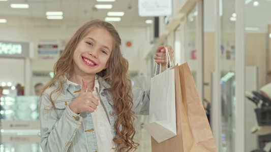 快乐可爱可爱的小女孩在购物中心露出拇指视频