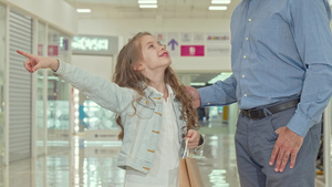 快乐的小女孩对着儿童商店在商场购物与她的父亲11秒视频