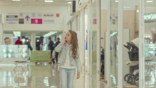 可爱的小女孩拿着购物袋在商场散步视频