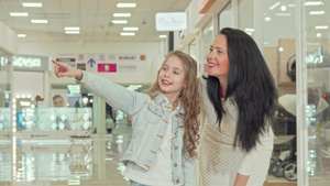 可爱的卷发小女孩和妈妈一起在商场购物11秒视频