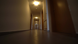 低角度电影拍摄镜头向酒店走廊走去的第一视角中弹14秒视频