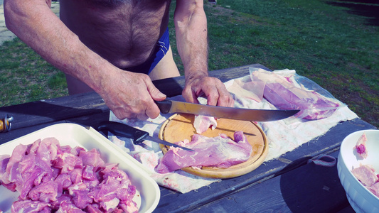 厨师正在用木制板上长长的屠宰刀切猪肉准备菜园烹饪用视频
