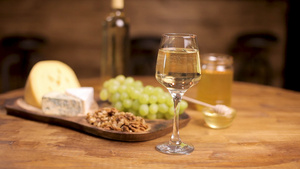 一杯白葡萄酒放在木桌上配有奶酪和葡萄8秒视频