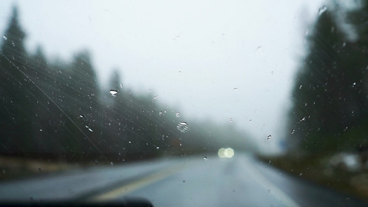 挡风玻璃上的雨滴模糊的汽车经过芬兰公路驾车视频