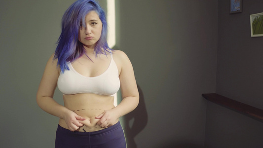 年轻女士在腹部捏她的脂肪她的腹部被压着视频