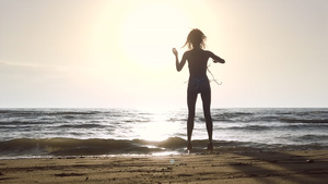 日落时在海滩上穿比基尼的女孩玩得开心跳舞19秒视频