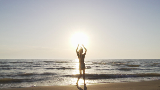 日落时在海滩上穿比基尼的月光女孩玩得愉快的跳跃视频