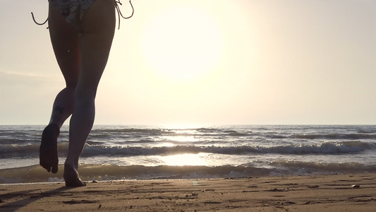 日落时在海滩上穿比基尼的月光女孩从水中流下跳跃视频