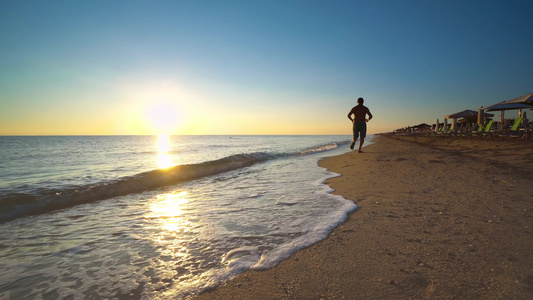 男子在日晒的海滩上奔跑视频