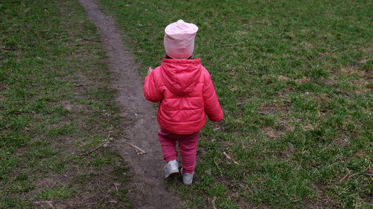 摄像头跟着一个幼儿女孩在春草上行走后视线视频