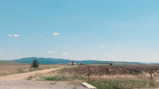 在田地和草原旁边的乡村公路上驾驶视频