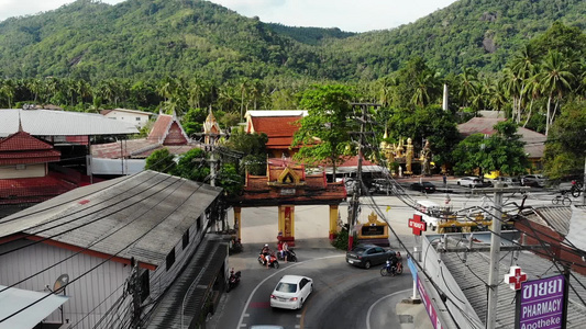 汽车沿着寺庙大门附近的道路行驶车辆沿着柏油路穿过泰国视频