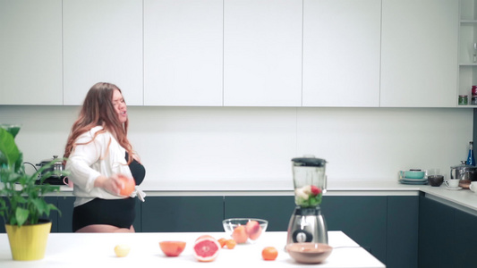 快乐地在厨房里跳舞手里拿着一个苹果身材曲线优美长着视频