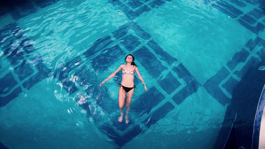 美丽的年轻女子她的身体被压在水上躺在水晶清澈的池塘视频