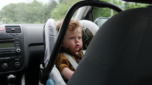 坐在汽车座椅上的一个小男孩的肖像25秒视频