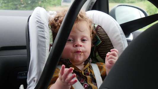 坐在汽车座椅上的一个小男孩的肖像视频
