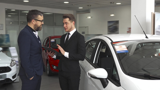 销售经理向汽车经销商的客户解释合同内容并视频
