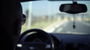 带着太阳眼镜的人驾驶着并接近公路上的工薪站13秒视频