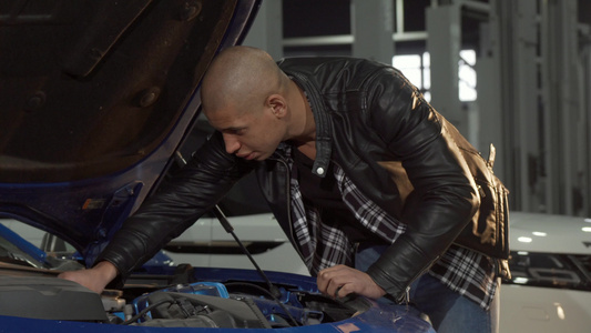 男子在车库检查他的汽车发动机视频