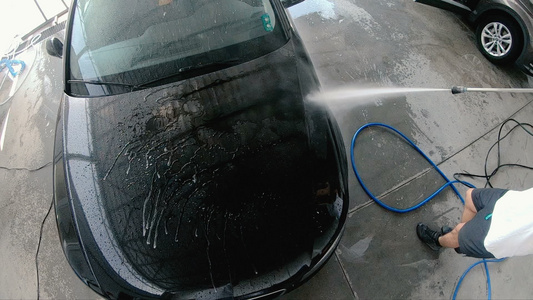 高压水男子慢动作清洗汽车的车辆视频